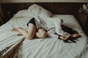 Woman in bed hiding her head 